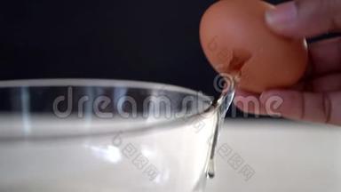 厨师手把一个鸡蛋<strong>打碎</strong>到<strong>玻璃</strong>碗里。 特写宏观镜头